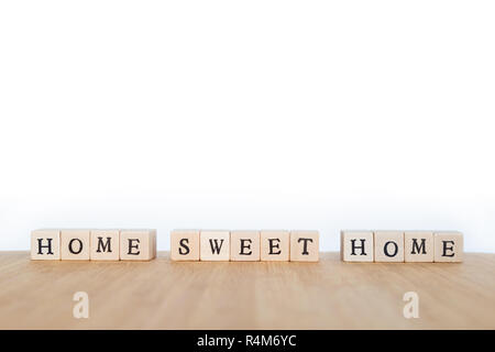 L'accent sur l'expression 'Home Sweet Home' réalisé de bloc en bois dés avec des lettres sur une table en bois. Profondeur de champ. Copier l'espace. Banque D'Images