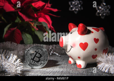Composition festive avec bitcoin couleur argent pièces souvenirs, cochon blanc et rouge de l'argent banque et décor de Noël. Focus sélectif. Plan de l'étoile de Noël Banque D'Images
