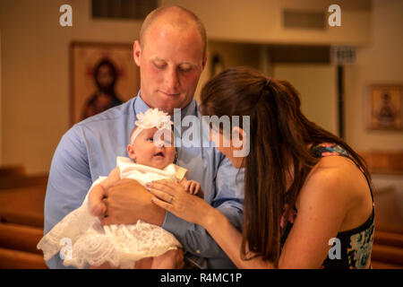 Un couple avec un nouveau-né fils d'attendre à participer à leur baptême de l'enfant à une Laguna Niguel, CA, l'église catholique. Banque D'Images