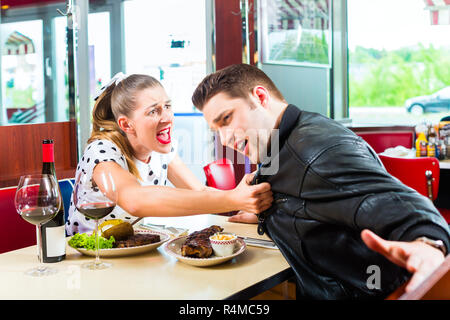 Couple boire et manger dans restaurant fast food Banque D'Images