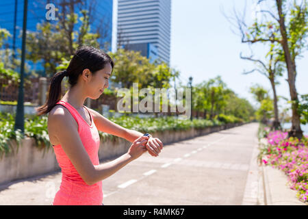 Femme sport courir avec smart watch in park Banque D'Images