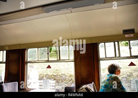Une passagère regarde par la fenêtre d'un wagon de chemin de fer sur la Loire et le chemin de fer à vapeur du Warwickshire, Royaume-Uni Banque D'Images