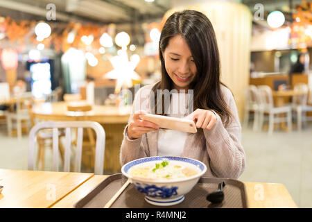 Woman taking photo dans son restaurant de ramen Banque D'Images