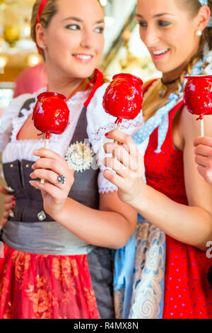 Friends eating Candy Apples à l'Oktoberfest Banque D'Images