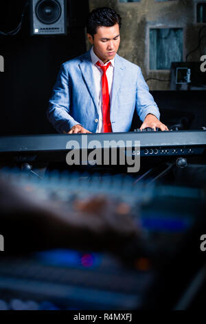 Clavier asiatique jouant en studio d'enregistrement Banque D'Images