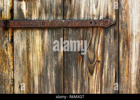 Détail de la texture du bois d'épinette sur l'ancienne porte avec charnières métalliques rouillées Banque D'Images