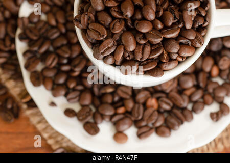 Les grains de café dans la tasse et soucoupe Banque D'Images