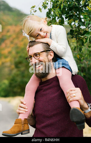 Father giving daughter piggyback ride Banque D'Images