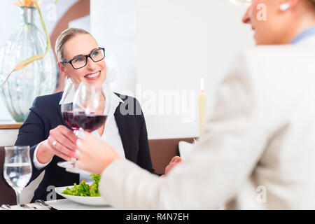 Les femmes sur business lunch toasting with wine Banque D'Images