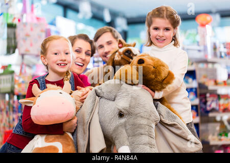 Famille avec l'éléphant au magasin de jouets en peluche jouant Banque D'Images