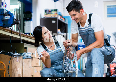 La femme et l'homme comme la mécanique vélo à l'atelier Banque D'Images