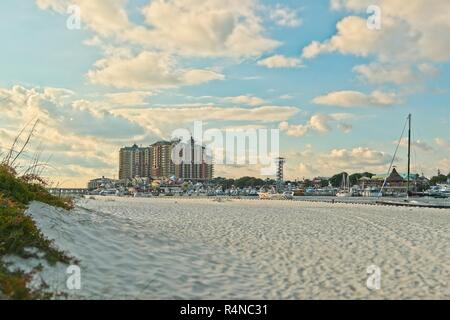 Plage de sable blanc et de dunes avec la Grande émeraude et de loisirs HarborWalk Village à la destin Florida sport commercial flotte de pêche amarrés à la marina. Banque D'Images