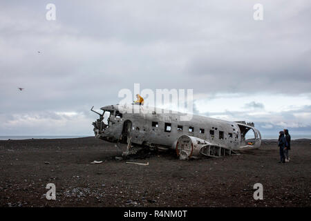 Un touriste prend vos autoportraits avec un bourdon comme il est situé au-dessus de l'épave d'un avion DC de l'US Navy qui s'est écrasé sur une plage dans le sud de l'Islande le 21 novembre 1973. L'endroit s'est écrasé en raison de faible niveau de carburant ou cerise sur le moteurs et tous à bord ont survécu. Après l'écrasement de l'avion privé de la Marine de moteurs et d'autres éléments valables mais laisse le fuselage principal sur la plage de sable noir près de Solheimasandur. Aujourd'hui, en grande partie grâce à la géolocalisation d'Instagram, l'avion est une destination populaire pour les photographes et les amateurs d'aventure visiter l'Islande. Banque D'Images