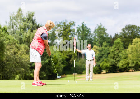 Senior woman practicing with golf pro Banque D'Images