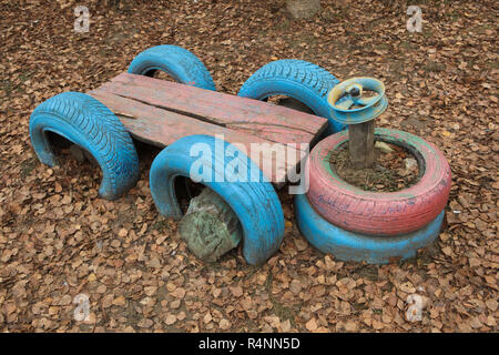 Voiture jouet fabriqué à partir de vieux pneus et de journaux sur l'aire de jeu pour enfants à Ivanovo, Russie. ATTENTION : Cette image fait partie d'un reportage photo de 18 photos avec le même jeu. Banque D'Images