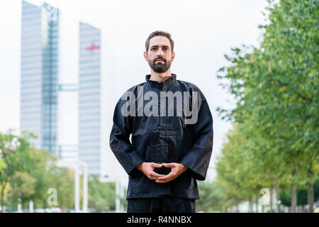 Man meditating faisant arts martiaux en ville Banque D'Images