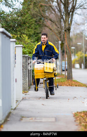 Postman équitation son vélo cargo réalisation mail Banque D'Images