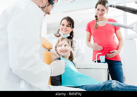 Dentiste traitant l'ensemble de la famille dans son bureau Banque D'Images