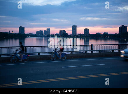 Vue latérale des deux cyclistes le long pont sur la Charles River au coucher du soleil, Boston, Massachusetts, USA Banque D'Images