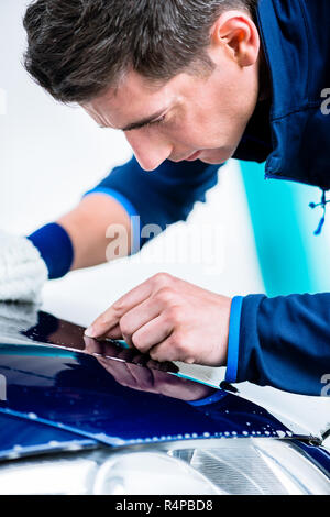 L'homme qui travaillent dur avec voiture de polissage microfibre blanche mitt Banque D'Images