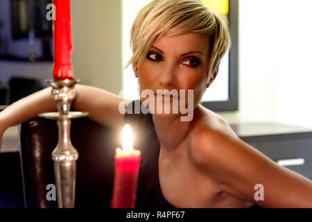 Femme blonde assise sous des bougies Banque D'Images
