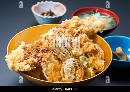 Tempura de crevettes frites et des légumes dans un bol à fond noir Banque D'Images