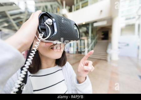 Femme essayant sur vr appareil dans shopping centre Banque D'Images