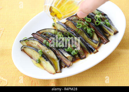 Aubergines grillées avec de l'huile et l'oignon sur plateau blanc Banque D'Images