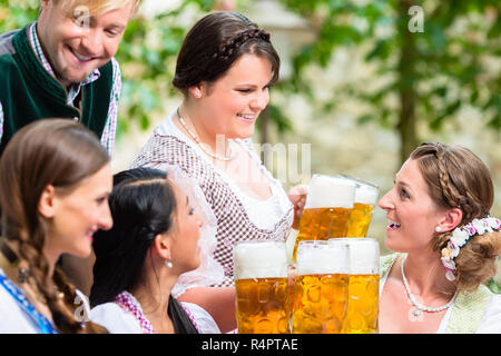 Waitress serving beer in beer garden Banque D'Images
