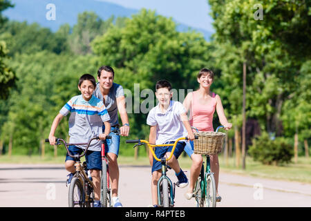 Famille de quatre sur l'excursion en vélo en été Banque D'Images