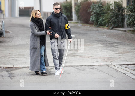 Aider une femme aveugle sur Street Banque D'Images