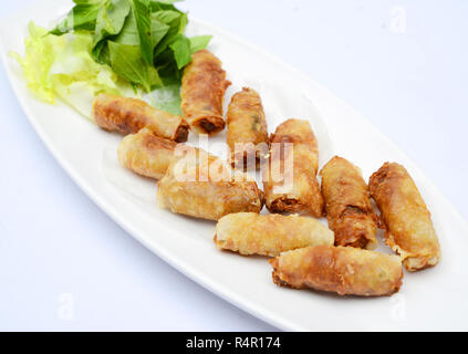 Rouleaux de printemps vietnamiens frit avec des herbes sur le plat blanc Banque D'Images