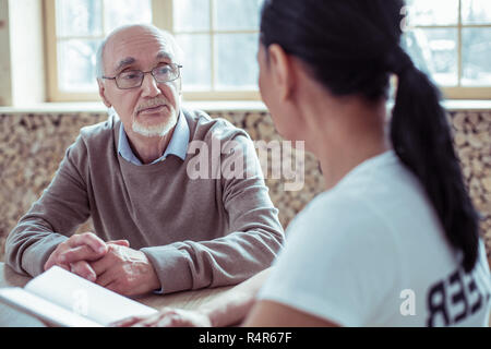 Serious mature man looking at sa travailleuse sociale Banque D'Images