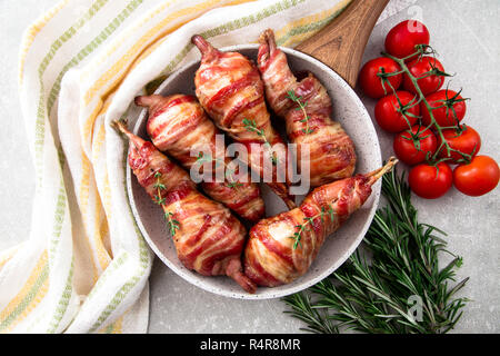 Caille cuit enrobé de bacon dans une poêle avec un peu d'épices Banque D'Images