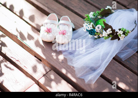 Chaussures Enfant avec sa tête blanche voile sur fond de bois Banque D'Images