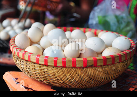 Blanc de poulet oeufs dans le panier de bambou Banque D'Images