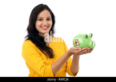 Jeune femme indienne d'économiser de l'argent dans la tirelire Banque D'Images