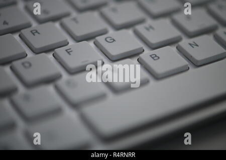 Blanc slim clavier minimaliste close up dans la nuit noire éclairée par la lumière de l'écran Banque D'Images