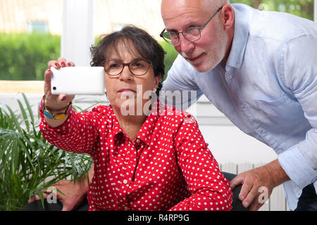 Cheerful young couple at home selfies Banque D'Images