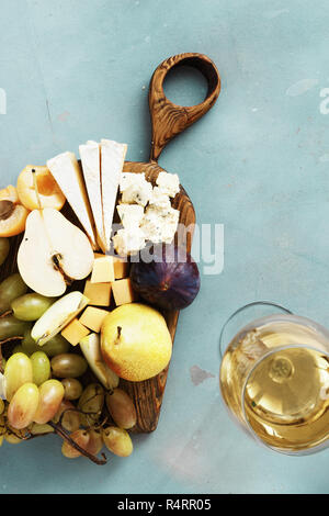 Table des hors-d et le vin. Fruits et fromage sur planche de bois sur fond de pierre. Hors-d'Vin Banque D'Images