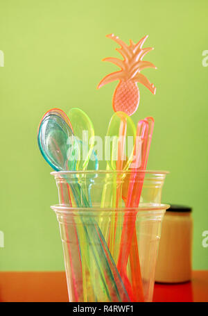 Pailles colorées en verre, cuillère en plastique et spatule en plastique Ustensiles outil pour la crème glacée. De couleur paille. Pile de couleur en plastique. Banque D'Images