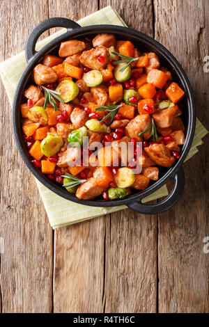 Poulet avec légumes cuits en sauce grenade close-up dans une poêle sur la table. Haut Vertical Vue de dessus Banque D'Images