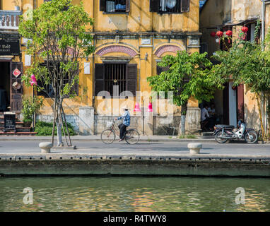 La ville de Hoi An une caledonie dame vietnamienne de rouler à vélo dans la vieille ville UNESCO de Hoi An au Vietnam. Banque D'Images