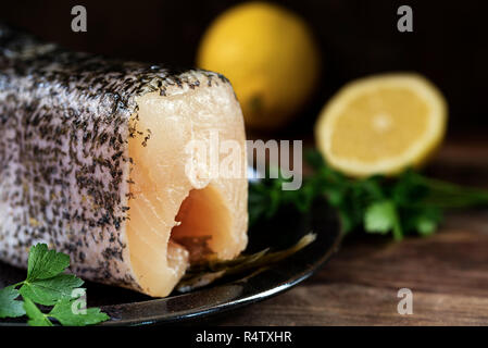 Matières le grand brochet, poissons frais nettoyés et préparés pour la cuisson, griller ou frire sur une planche de bois rustique, fond sombre, Close up avec certains f Banque D'Images