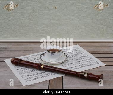 Anglais céramique fine porcelaine avec décor floral peint à la main sur un bord doré bleu, sur une feuille de musique Banque D'Images