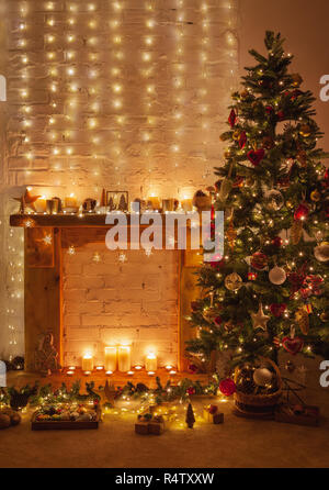 Belle décoration de Noël chaleureux, Cheminée avec bois de cheminée, illuminé de Noël avec boules vert or rouge et ornements, étoile li Banque D'Images