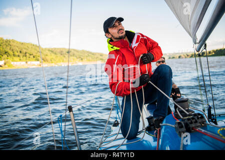 Jeune homme travaillant sur la voile de bateau, vie active, l'été sport concept Banque D'Images