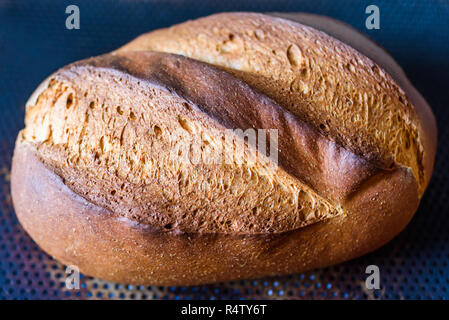 Farine artisanale de refroidissement miche de pain sur une plaque de cuisson. Banque D'Images