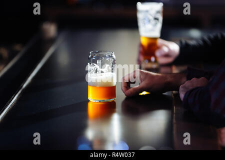 Un homme jouissant d'une pinte de bière artisanale dans un bistrot-brasserie Banque D'Images