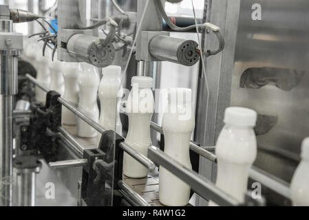 Les bouteilles de lait en plastique sur la courroie du convoyeur. l'équipement à l'usine de produits laitiers Banque D'Images